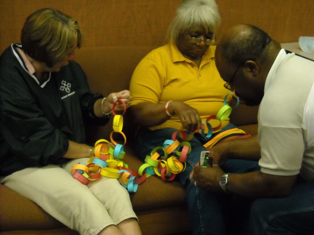 three team members work on assembling some 1,400 links in the prayer chain.