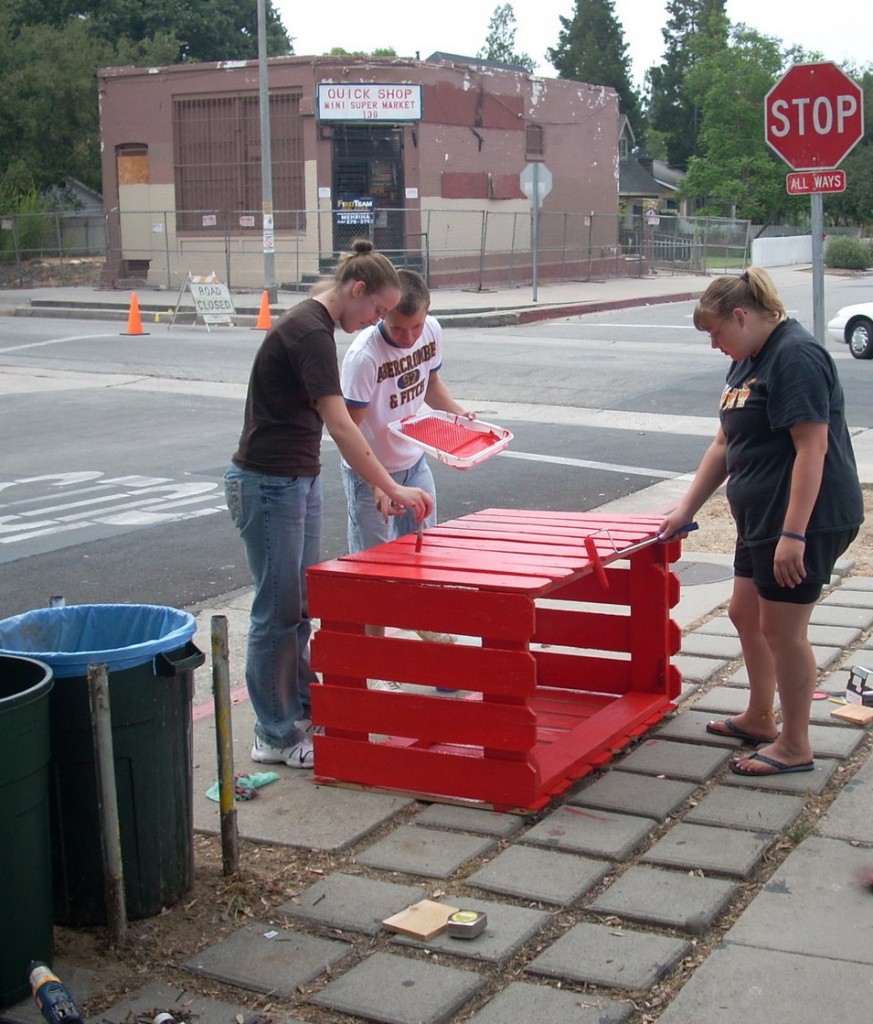 emmah, mitch and kaitlyn work on a recycling bin in front of harambee